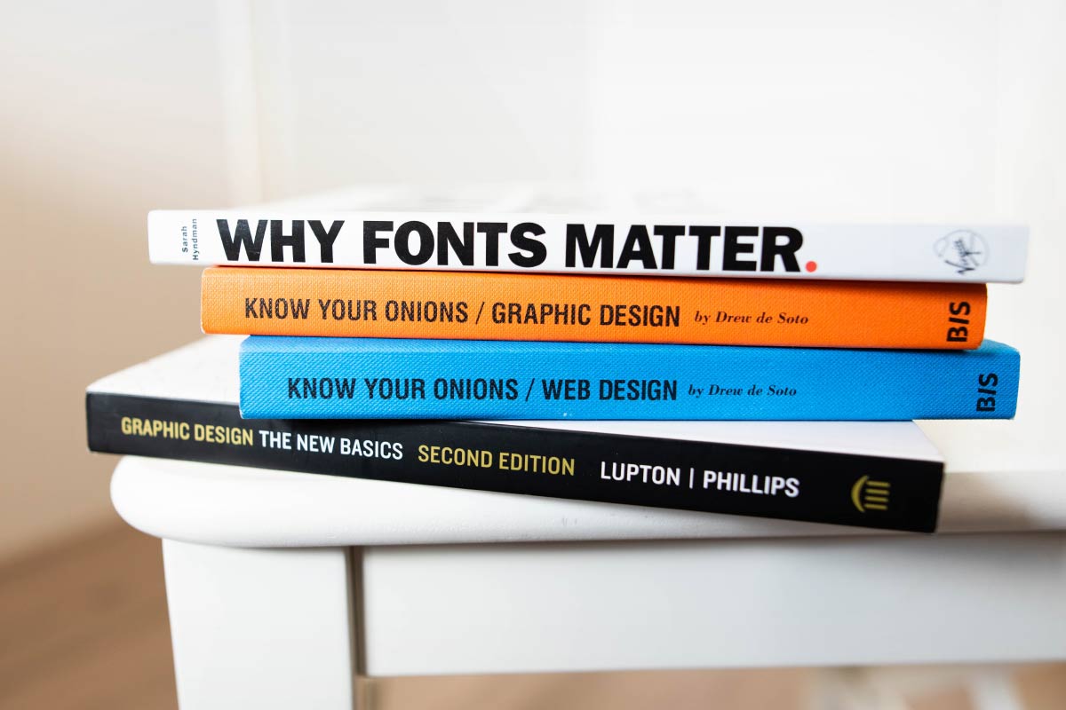 Stack of books on fonts, graphic design, web design, etc.