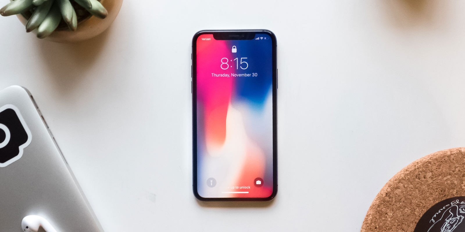 Apple iPhone showing home/lock screen on desk
