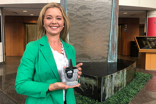 Tina from UofL Health Pharmacy Services Team holds award